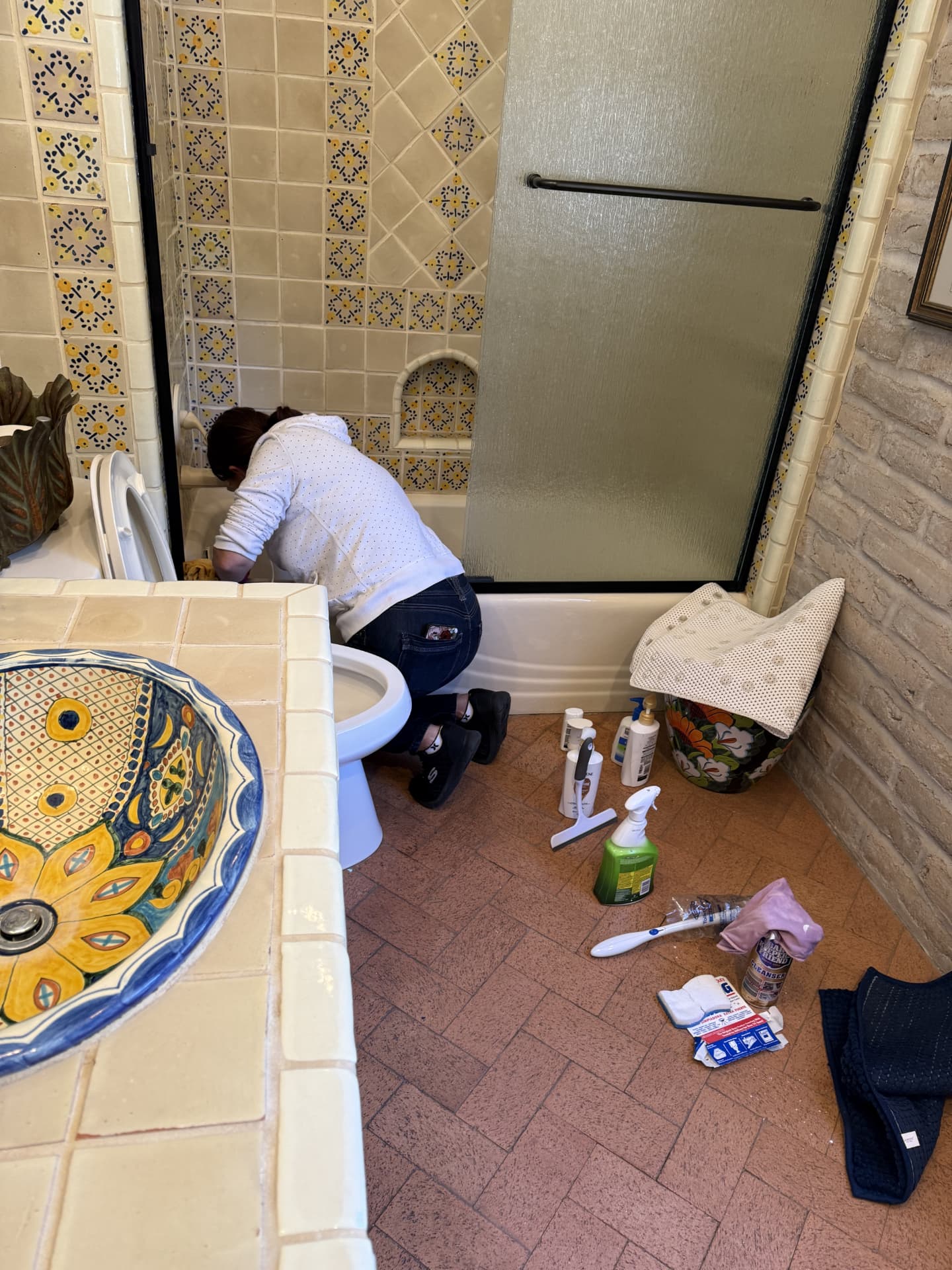 Team member carefully cleaning a bathroom tub and tile surfaces