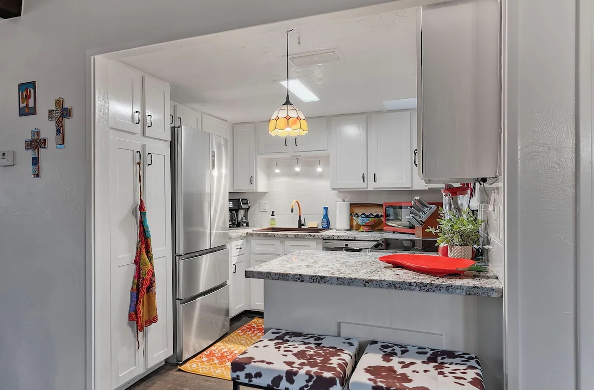 Clean kitchen with wiped counters and spotless white cabinets
